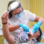 Dental Practitioner attending to a patient (in sitting position)